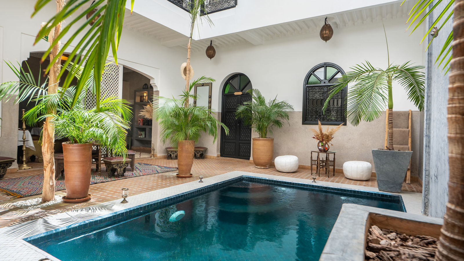 Patio luminoso del Riad Dabachi con estanque y palmeras