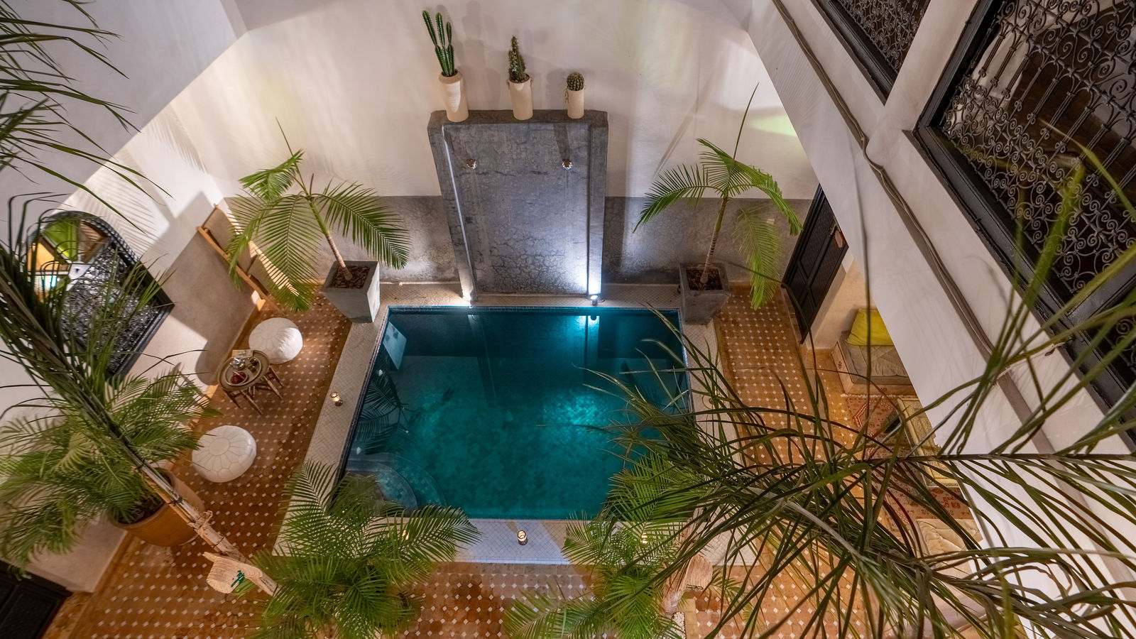 Patio luminoso del Riad Dabachi con estanque y palmeras